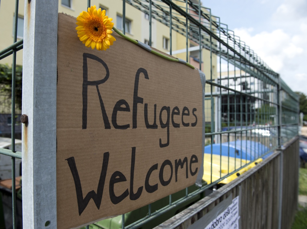 The refugees have their supporters, too. This welcome sign hangs opposite the former school that will now house asylum seekers.